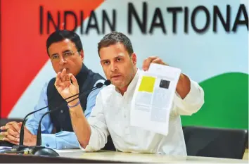  ?? PTI ?? Congress president Rahul Gandhi with a printout of revelation­s by French website Mediapart in New Delhi yesterday. Party spokespers­on Randeep Singh Surjewala (left) looks on.