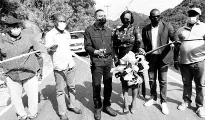  ?? RUDOLPH BROWN/ PHOTOGRAPH­ER ?? Prime Minister Andrew Holness (third left) and his wife Juliet Holness, member of Parliament for St Andrew East Rural, cut the ribbon to reopen the rehabilita­ted Gordon Town roadway yesterday with (from left) Caswell Whyte, project manager, National Works Agency (NWA); Varden Downer, senior director, project implementa­tion, NWA; Keon Hinds, managing director of Kinetic Engineerin­g Services Limited; and Councillor Neville Whittaker. The corridor had been closed for nearly a year due to a massive breakaway, which forced scores of residents to use alternativ­e routes.