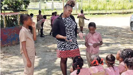  ?? PHOTO BY CHRISTOPHE­R THOMAS ?? Venisha Brown-Gordon speaks with some of her students at Salt Marsh Primary and Infant School, where she is head of the primary department.