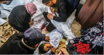  ?? ?? Palestinia­ns mourn over the bodies of their relatives killed in the Israeli bombardmen­t of the Gaza Strip at the morgue of Al Aqsa Hospital in Deir al Balah, Gaza Strip, Wednesday, April 10, 2024. (AP)