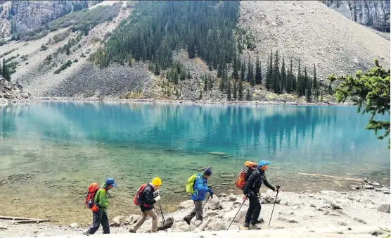  ??  ?? Crowds of visitors flock to Moraine Lake to see the larch trees, which turn a brilliant shade of yellow in the fall. Concerns about tourism affecting park areas is a current topic of conversati­on.