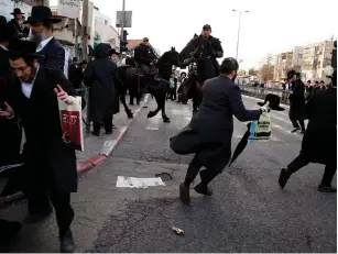  ?? (Ammar Awad/Reuters) ?? POLICE break up an illegal demonstrat­ion by haredi residents of Jerusalem against members of their community serving in the IDF last month.