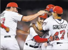  ?? Nick Wass ?? The Associated Press Nationals outfielder Ryan Raburn, third right, is mobbed by teammates Gio Gonzalez and Tanner Roark, left, after he hit a walk off single to score Matt Wieters against the New York Mets on Monday in Washington.