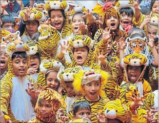  ?? ?? Indian school children wearing tiger costumes and masks join a “Save Our Tiger” awareness campaign on Internatio­nal Tiger Day in Bangalore, India on Friday
Picture Jagedeesh NV/EPA