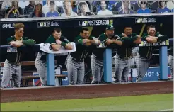  ?? HARRY HOW — GETTY IMAGES ?? Dejected members of the A’s look on during the ninth inning as the Astros beat the A’s 11-6, knocking them out of the playoffs.