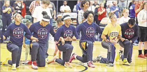  ?? AP ?? Indiana Fever players kneel during playing of national anthem last year in Indianapol­is in example of white athletes joining in protests.