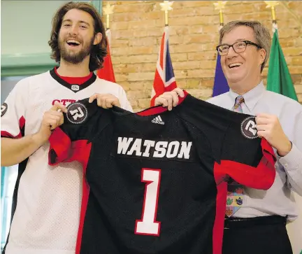  ?? ERROL McGIHON ?? Ottawa Redblacks’ receiver Scott Macdonell presents Mayor Jim Watson with a personaliz­ed version of the team’s new jersey for the upcoming season. There had been complaints in the past the numbers were hard to identify from the stands.