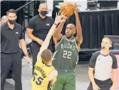  ?? QUINN HARRIS/GETTY ?? The Bucks’ Khris Middleton (22) hits the winning shot in overtime over the Heat’s Duncan Robinson on Saturday in Milwaukee, Wisconsin.