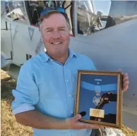  ?? ?? Top: Angele BennettEng­ele, Steve Bennett's daughter holds his Medal of Honor in front of OV10 Squadron's OV-10D flanked by pilot/restorer Matt Nightingal­e the group's founder Mike Manclark (in light blue shirt) and photo plane pilot JJ Johnson (in black shirt).
Above: OV-10 Squadron founder Mike Manclark poses with Steve Bennett’s Medal of Honor. (Photos by Joseph Fischer)