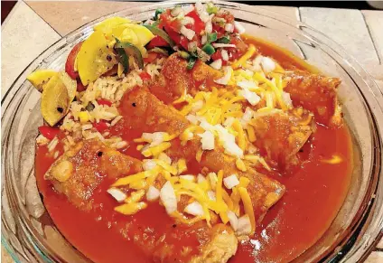  ?? [PHOTO BY DAVE CATHEY, THE OKLAHOMAN] ?? Cheese enchiladas in red chile sauce with Spanish Rice and Calabacita­s con hongos.