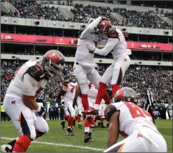  ??  ?? Tampa Bay Buccaneers’ Mike Evans (13) and Jameis Winston (3) celebrate after Evans’ touchdown against the Philadelph­ia Eagles.