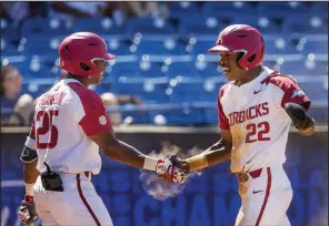  ?? NWA Democrat-Gazette/BEN GOFF ?? Freshman Christian Franklin (left) congratula­tes teammate Curtis Washington after Washington scored in the eighth inning of Arkansas’ victory over Mississipp­i on Wednesday at the SEC Tournament in Hoover, Ala.