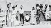  ?? Office of Naval Intelligen­ce / U.S. National Archives via AP ?? The woman seated with her back to the camera is perhaps aviator Amelia Earhart, gazing at what may be her crippled aircraft loaded on a barge.