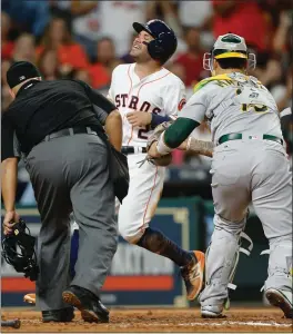  ?? BOB LEVEY — GETTY IMAGES ?? The Astros’ Jose Altuve is tagged out by A’s catcher Bruce Maxwell in attempting to score in the third inning. The Astros eventually won, ending the A’s winning streak.