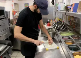  ??  ?? Dès qu’il y une accalmie, Jordan anticipe le service du soir en préparant les légumes allant dans les burgers.