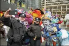  ?? RICK KAUFFMAN — DAILY TIMES ?? Members of the Hegeman String Band pose for a selfie with Philadelph­ia police officers during the Mummers Parade Friday.