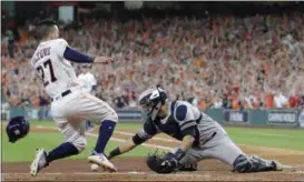  ?? DAVID J. PHILLIP — THE ASSOCIATED PRESS ?? The Astros’ Jose Altuve scores the game-winning run past Yankees catcher Gary Sanchez during the ninth inning of Game 2 of the American League Championsh­ip Series in Houston.