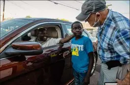  ?? ?? Doherty talks to Sefadine Nour, from Sudan, and his son Ismail, 10, outside the Refugee Center on Tuesday. Over the years, the U.S. Committee for Refugees and Immigrants in Albany has resettled about 4,500 refugees.