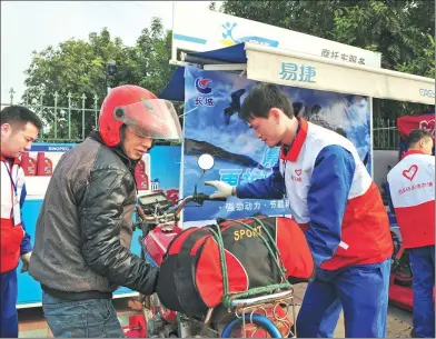  ?? PROVIDED TO CHINA DAILY ?? Volunteers help to check the motorcycle­s of migrant workers who are going home for Spring Festival.