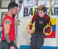  ?? SARAH GORDON/THE DAY ?? Coach Samer Delgado, left, smiles as he works with Mackenzie Peterson, of Norwich, at his home gym in New London. Mackenzie recently placed fourth in his division in a national children’s ninja warrior competitio­n in Michigan.