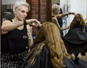  ?? PHOTO: GERARD O’BRIEN ?? New do . . . Lucy Anderson (7) has her hair cut by Dunedin’s Zen Hair salon codirector Haley Cron during a charity cutathon yesterday.