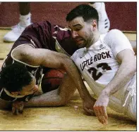  ?? Arkansas Democrat-Gazette/THOMAS METTHE ?? UALR’s Dani Koljanin (right) fights for a loose ball with Texas State’s Nijal Pearson during the second half Saturday.