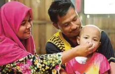  ??  ?? MOHD Afidi dan Roshashima­h bersama anak mereka, Nur Yusra Ainul Mardiah yang menghidap leukimia.