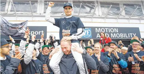  ?? FOTO: JÜRGEN TAP/ DTM/ ITR/ DPA ?? Geteilte Freude in Hockenheim: DTM-Champion Pascal Wehrlein wird von den Mitglieder­n seiner begeistert­en Crew gefeiert.