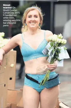  ??  ?? Street warrior On World Ovarian Cancer Day 2019, Fi handed out white roses, wearing very little bar a bra and pants