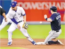  ?? FRANK GUNN, THE CANADIAN PRESS ?? Rays left-fielder Corey Dickerson steals second base as the ball gets past Blue Jays second baseman Rob Refsnyder on Tuesday.