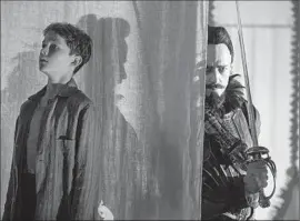  ?? Laurie Sparham Warner Bros. ?? LEVI MILLER, left, stars as Peter and Hugh Jackman as Blackbeard in the action adventure “Pan.” “The Martian” is expected to be No. 1 again this weekend.