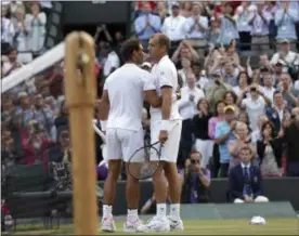  ?? TIM IRELAND — THE ASSOCIATED PRESS ?? Luxembourg’s Gilles Muller, right, greets Spain’s Rafael Nadal after winning their Men’s Singles Match on day seven at the Wimbledon Tennis Championsh­ips in London Monday.