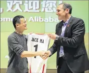  ?? ASSOCIATED PRESS ?? Pac-12 Commission­er Larry Scott, presenting a jersey to Jack Ma of the Alibaba Group e-commerce company earlier this week, was instrument­al in bringing the TexasWashi­ngton basketball game to China.