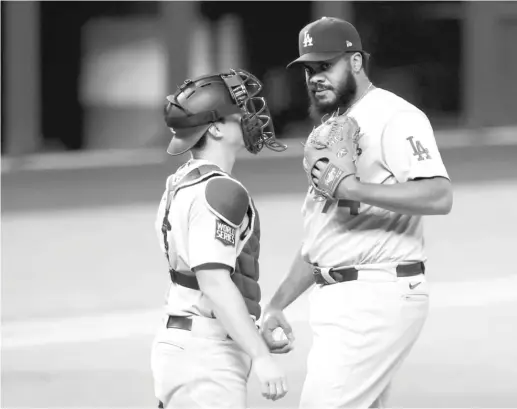  ?? TOM PENNINGTON/ GETTY IMAGES ?? Will Smith huddles with reliever Kenley Jansen on the mound during the ninth inning of Game 4 on Saturday night.