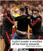  ?? HUW EVANS AGENCY ?? A pitch invader is wrestled off the field by stewards