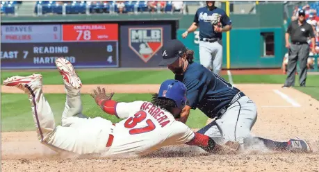 ?? Tom Mihalek / The Associated Press ?? Philadelph­ia’s Odubel Herrera is tagged out at home by Atlanta pitcher R.A. Dickey after a wild pitch during the sixth inning of Sunday’s game in Philadelph­ia.