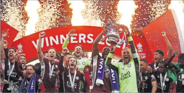  ??  ?? Los jugadores del Leicester levantan el título de FA Cup conquistad­o ayer en Wembley ante el Chelsea.