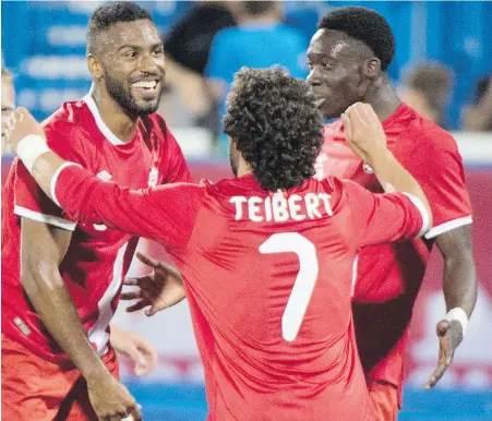  ??  ?? Canada’s Anthony Jackson-Hamel, left, celebrates his game-winning goal against Curaçao with teammates Russell Teibert and Alphonso Davies in Montreal on Tuesday. Davies, 16, became the youngest man ever to play for Canada.