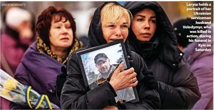 ?? EMILIO MORENATTI ?? > Larysa holds a portrait of her Ukrainian serviceman husband Volodymyr, who was killed in action, during his funeral in Kyiv on Saturday