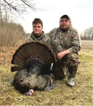  ?? FOR THE SUN- TIMES ?? Juggling baseball with turkey hunting, Caleb LaGrange ( left) bagged his first turkey with the help of Chris Elliott during the first of the youth turkey seasons inWill County.