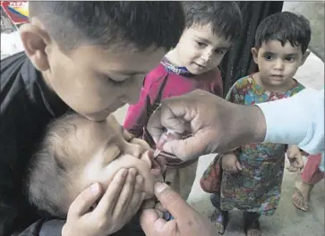  ?? K.M. Chaudary
Associated Press ?? A HEALTH WORKER gives a polio vaccine to a child in the eastern Pakistani city of Lahore. In the northern tribal areas, only six polio cases have been reported this year, compared with 56 in the same period a year ago.