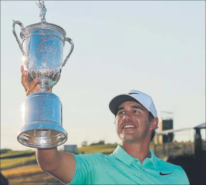  ??  ?? En su 15ª participac­ión en un Grand Slam, Brooks Koepka levantó el domingo el trofeo de campeón del Open de EE.UU. en Erin Hills