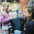  ?? PETER McCABE/ MONTREAL GAZETTE ?? Tess Christen, 6, gets help choosing jewelry from Olivia Gaston at a craft fair at Forest Hill school in St-Lazare on Saturday.