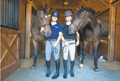  ?? KIM HAIRSTON/BALTIMORE SUN ?? Sarah Boston, left, poses with her horse, Diva, while twin sister Grace Boston holds the reins for Stellar at the McDonogh School Equestrian Center. The Bostons join approximat­ely a dozen equestrian­s from Maryland riding for Division I programs.