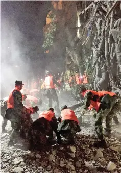  ??  ?? Chinese paramilita­ry police search for survivors after an earthquake in Jiuzhaigou in southwest China’s Sichuan province. — AFP photo