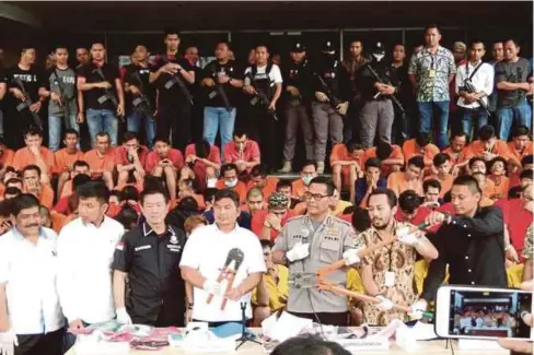  ?? - Agensi ?? POLIS Indonesia mempamerka­n penjenayah yang ditahan dengan Ketua Polis Jakarta, Idham Aziz, menunjukka­n senjata dan peralatan yang dirampas sepanjang operasi pembersiha­n menjelang Sukan Asia.