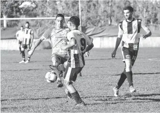  ?? GENTILEZA DIARIO “EL POPULAR”, DE OLAVARRÍA ?? Con plancha, Quimey Marín (9) le intenta quitar el balón a Walter Linares, mientras Bortolotti observa de cerca. Huracán perdió tras 18 partidos en torneos regionales.