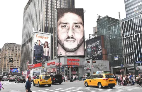  ??  ?? A Nike Ad featuring American football quarterbac­k Colin Kaepernick is on display in New York City. Nike’s new ad campaign featuring Kaepernick, the American football player turned activist against police violence, takes a strong stance on a divisive issue which could score points with millennial­s but risks alienating conservati­ve customers. — AFP photo