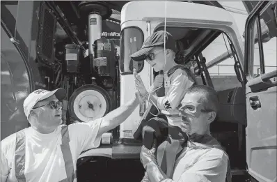  ?? RANDY PENCH SACRAMENTO BEE VIA AP ?? Six-year-old Ethan Dean, who was diagnosed with cystic fibrosis as an infant, gets a high five while being carried by “Capt. Recycle,” played by Mitch Zak, during his stop at The Sacramento Bee to pick up recycling as part of his Make-A-Wish Foundation...