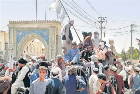  ?? AFP ?? Taliban fighters are seen standing atop a vehicle in the city of Kandahar, Afghanista­n, on Friday.